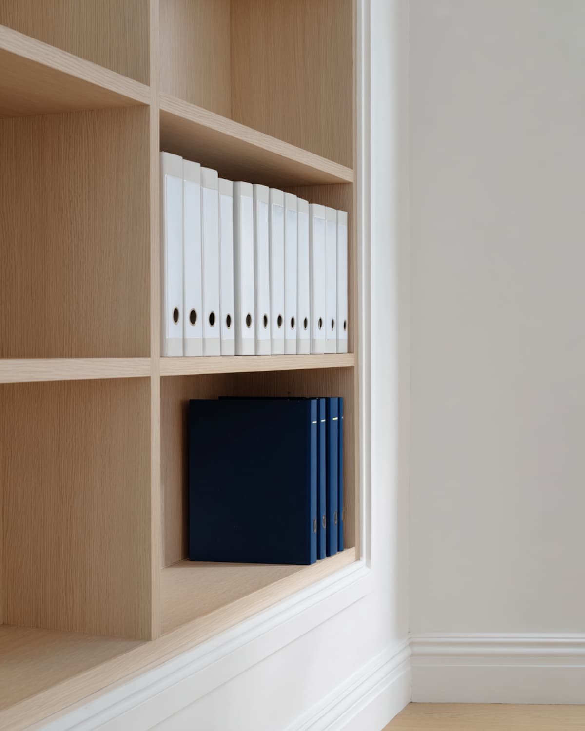 Une bibliothèque bien rangée, classeurs et documents sur les étagères