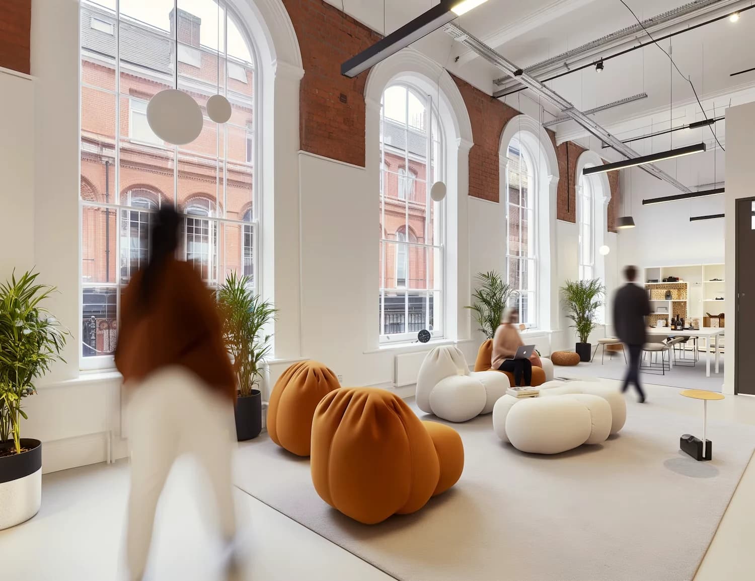 Un espace de bureau lumineux avec du mobilier design et des collaborateurs qui circulent