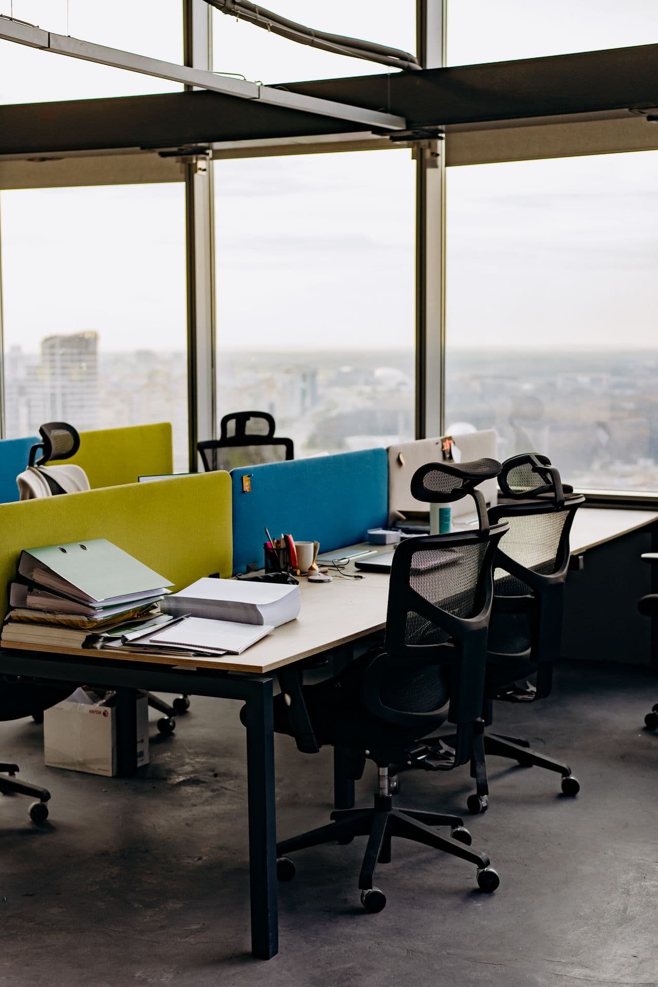 Des postes de travail vides séparés par des cloisons colorées