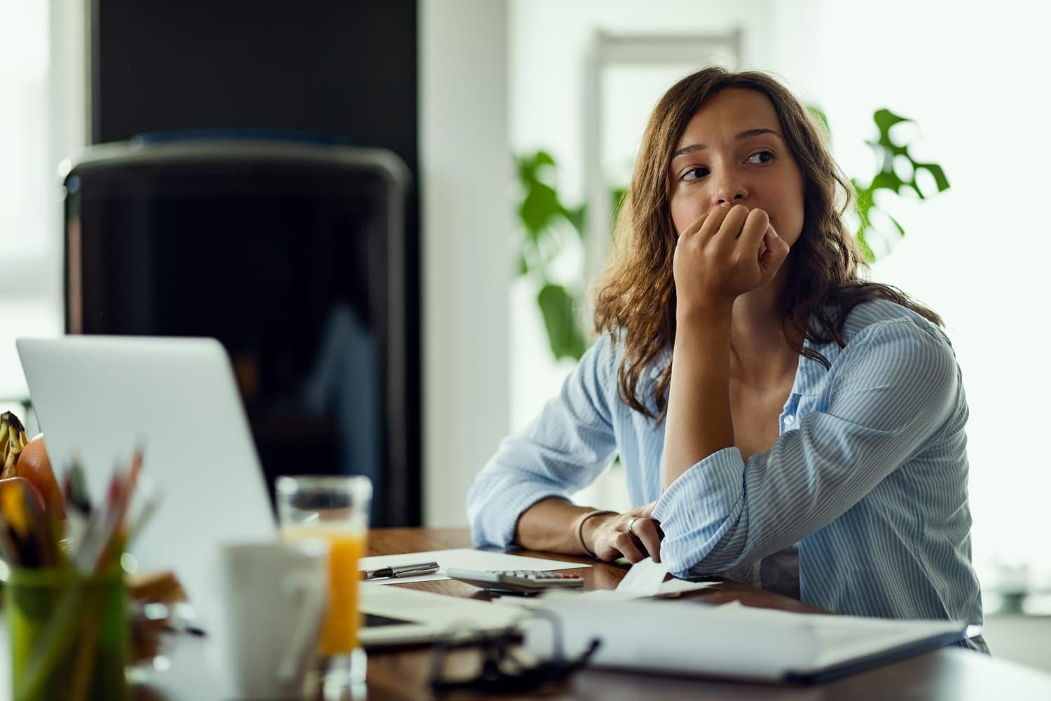 Une salariée pensive et préoccupée devant son ordinateur