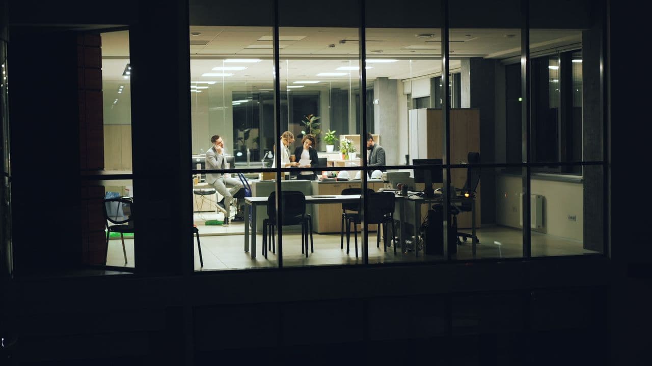 Des bureaux éclairés de nuit, vus depuis l’extérieur du bâtiment