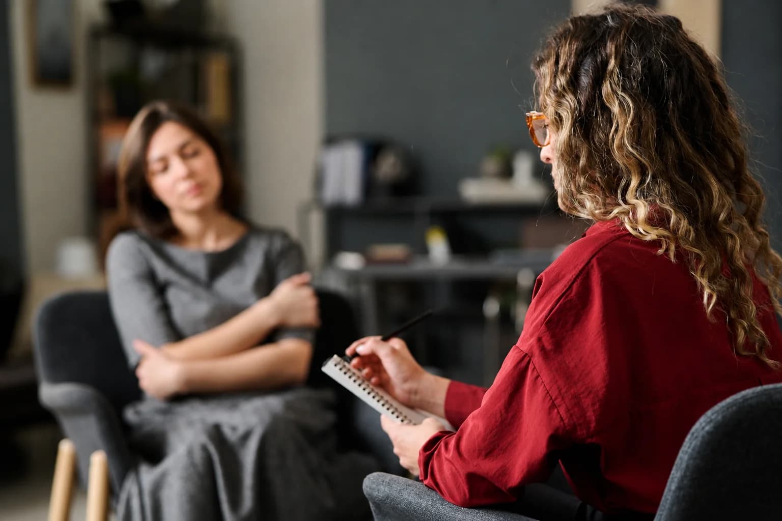 Une psychologue prend des notes pendant un entretien avec une salariée