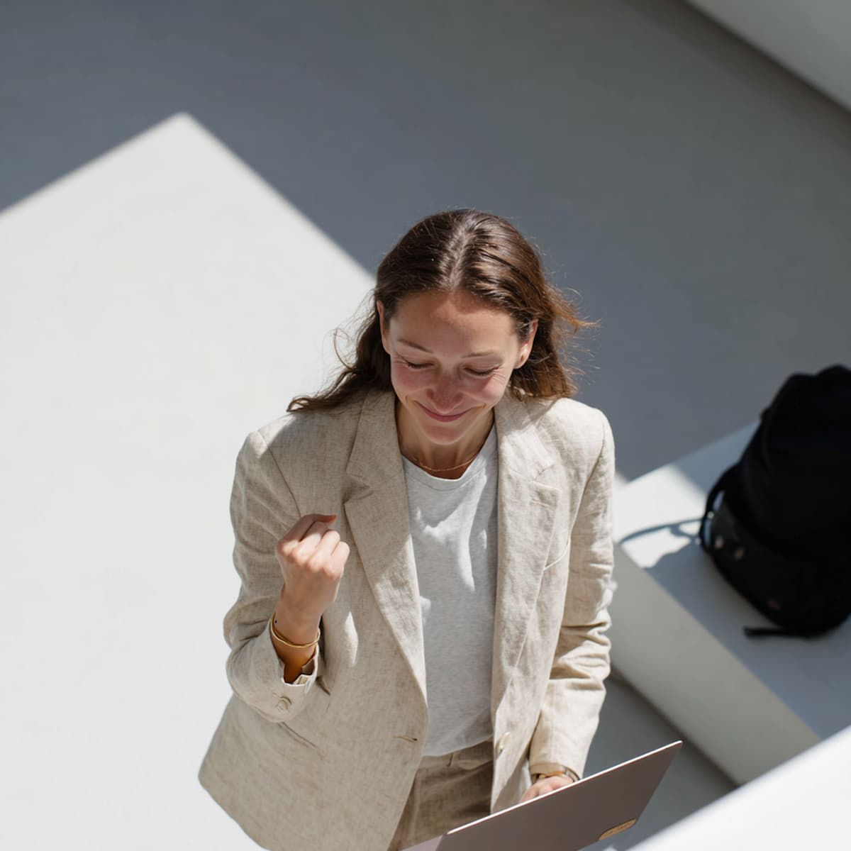 Une salariée célèbre une réussite, ordinateur portable à la main