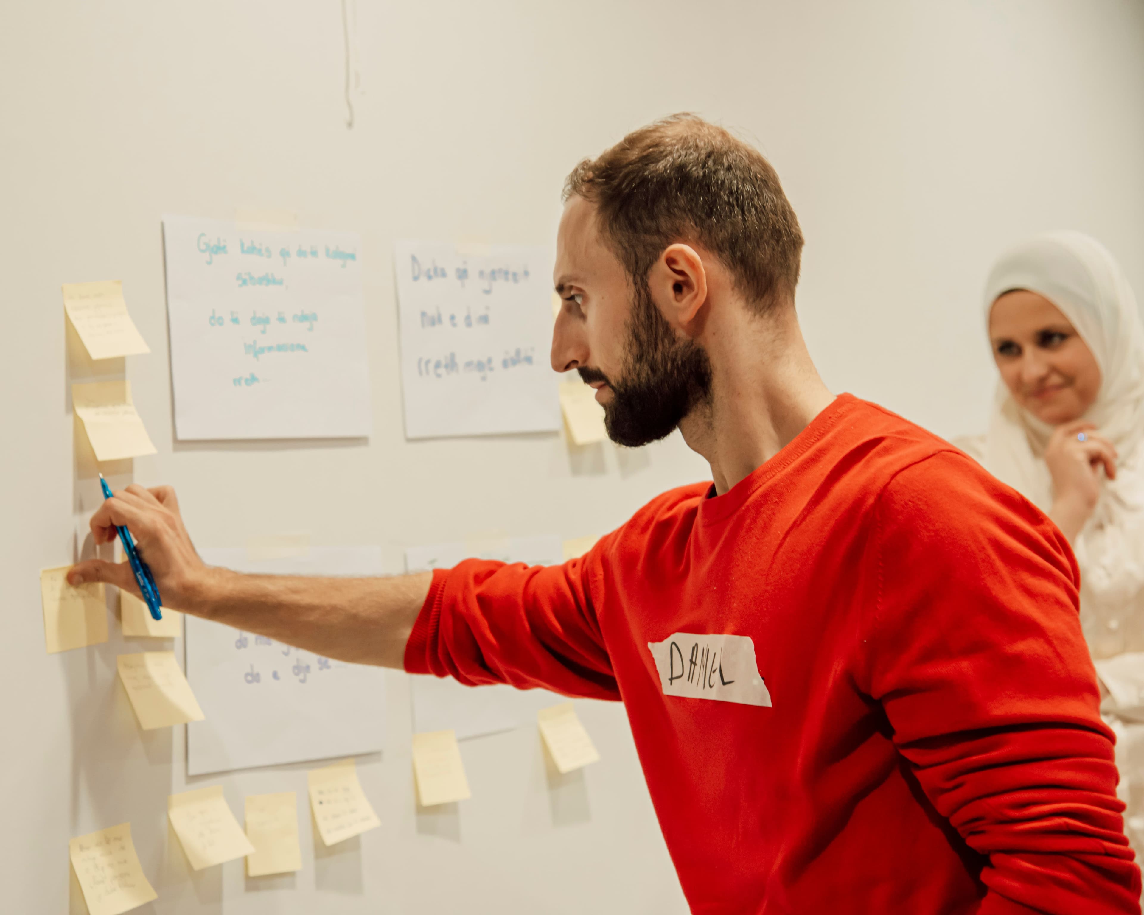 Un participant note une idée sur un post-it pendant un atelier