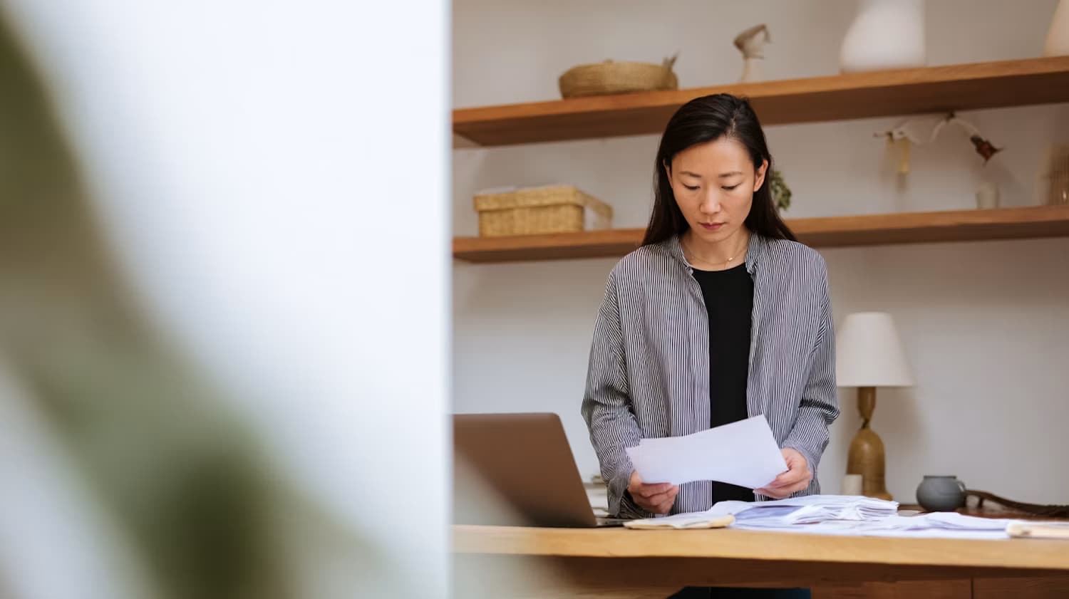 Une collaboratrice consulte des documents devant son ordinateur portable