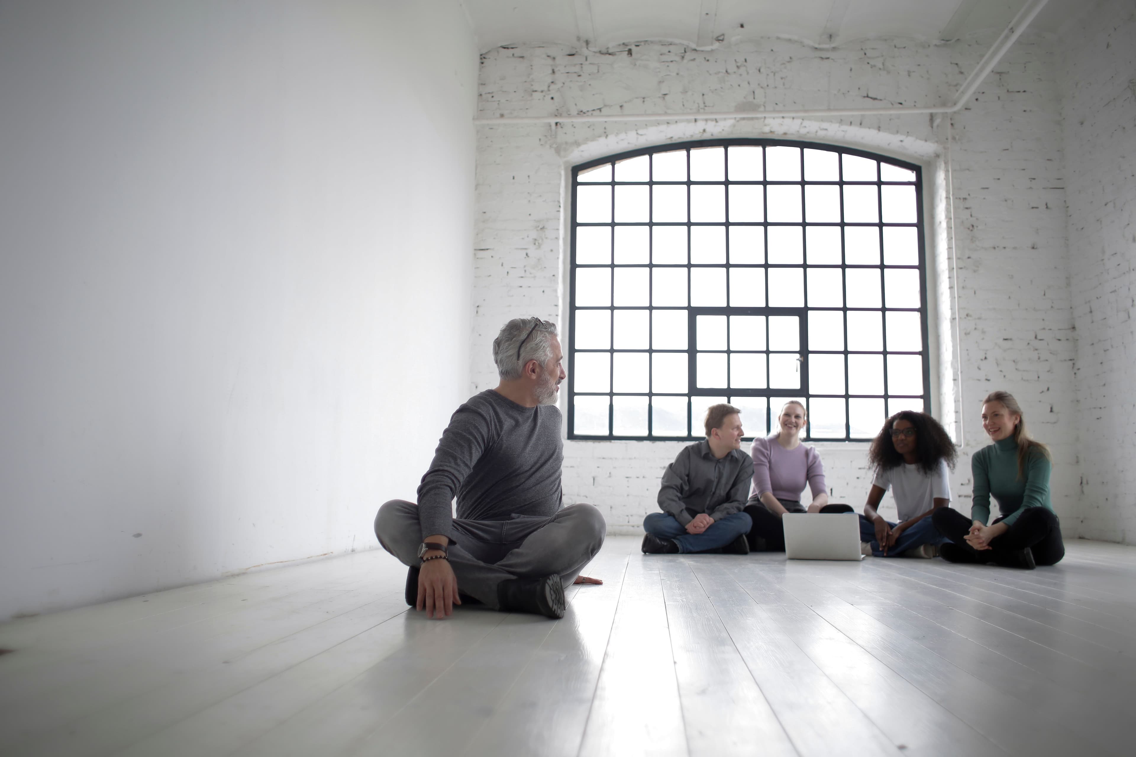 Un formateur échange avec un groupe de participants assis au sol pendant une session de formation PSSM